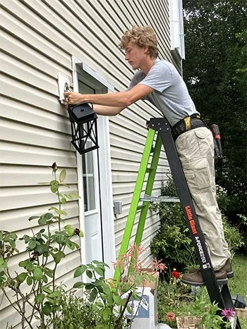 Light of the World electrician installing an exterior light